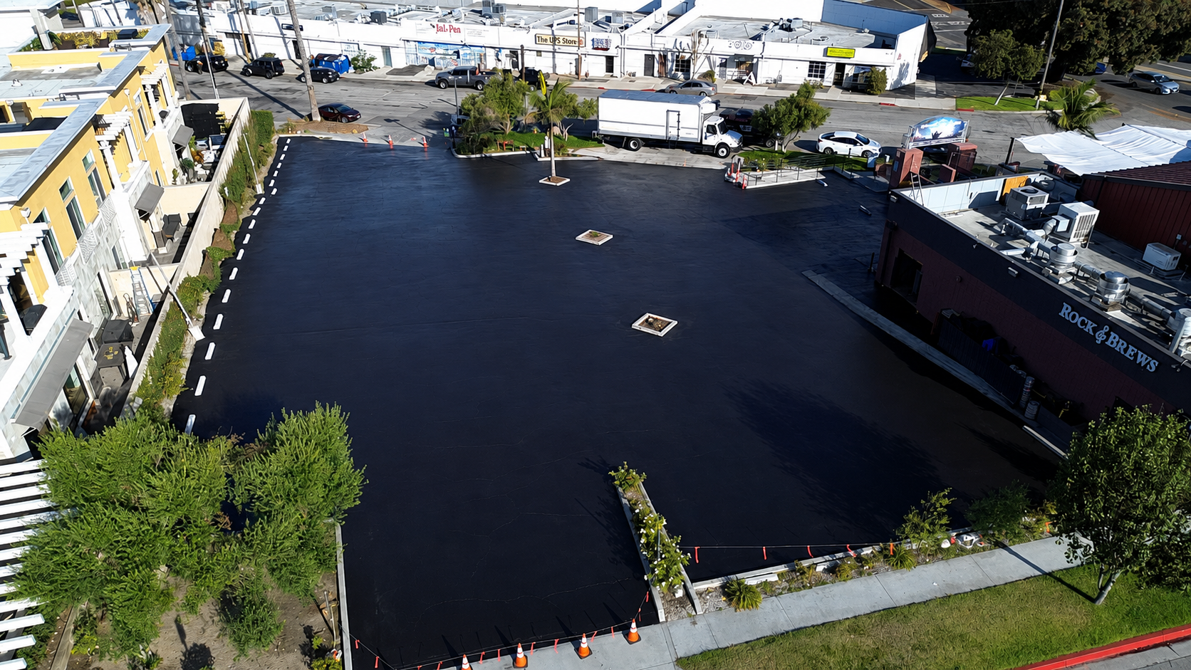 Aerial view of a freshly seal coated and striped commercial parking lot in Redondo Beach, California