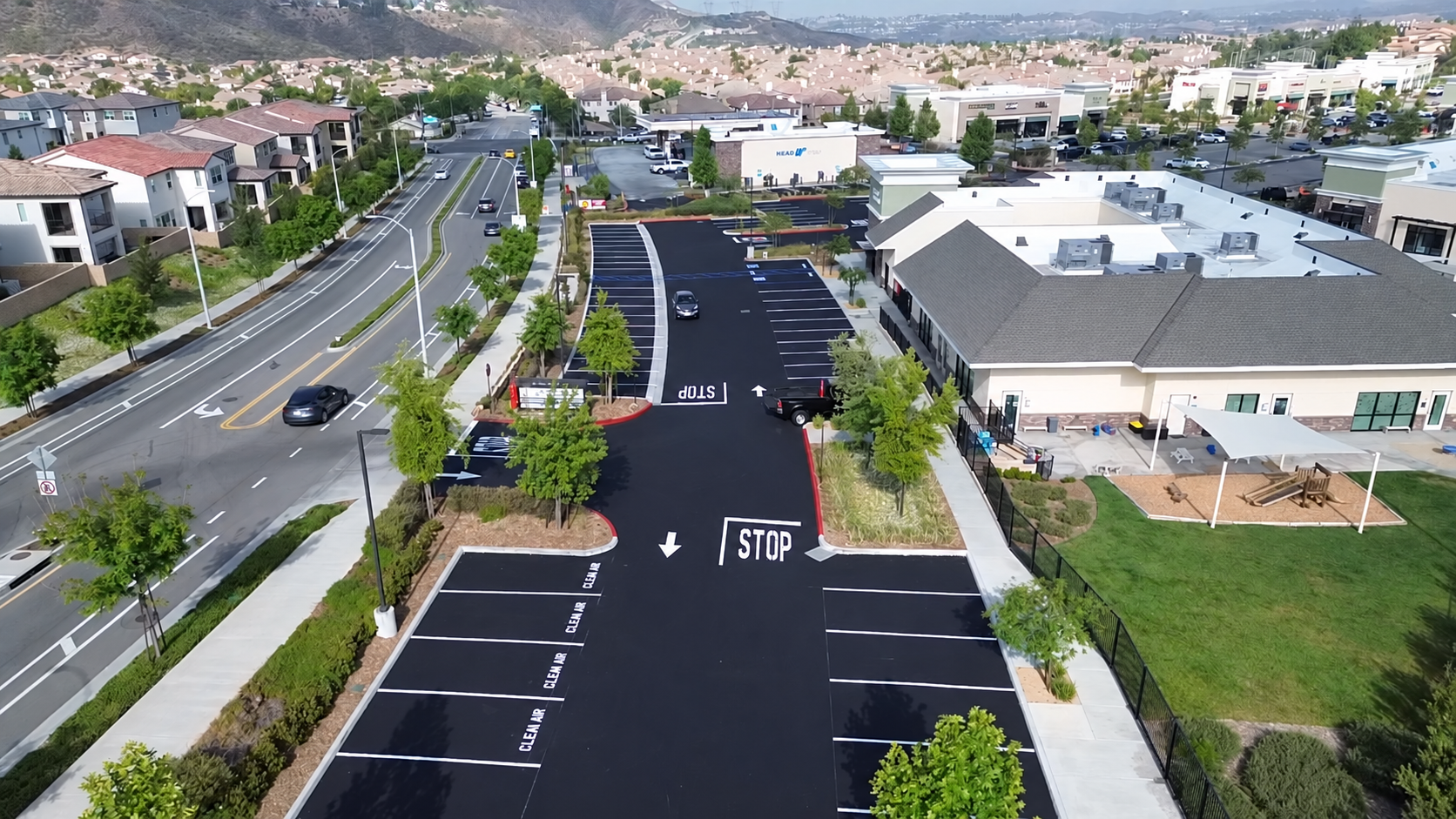 Aerial view of a freshly sealed and striped commercial parking lot.